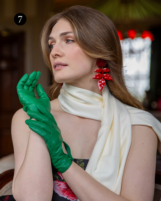 Woman wearing classic driving gloves in emerald green with pashmina inside. 