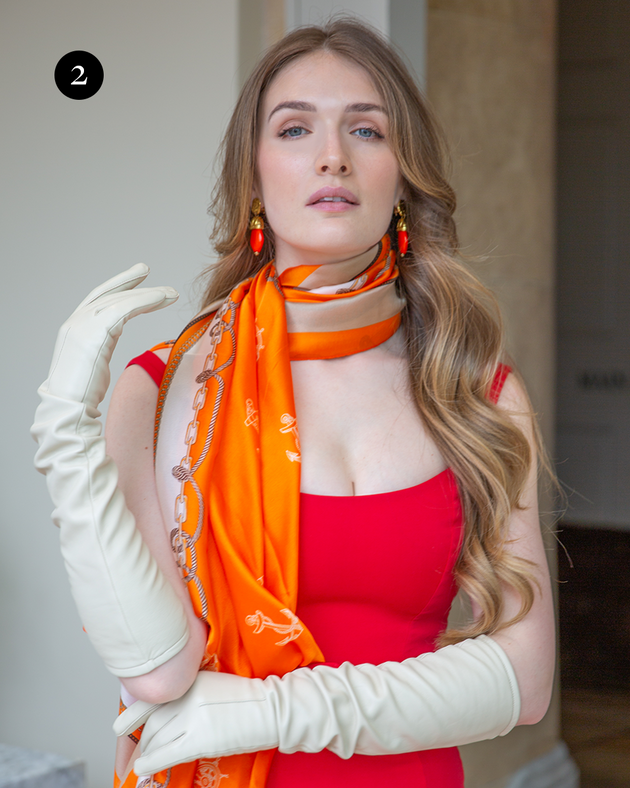 Woman wearing long leather gloves with single-point in ivory with red and orange accents. 