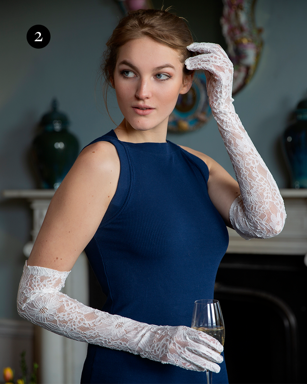Woman wearing long white lace floral gloves with blue dress. 
