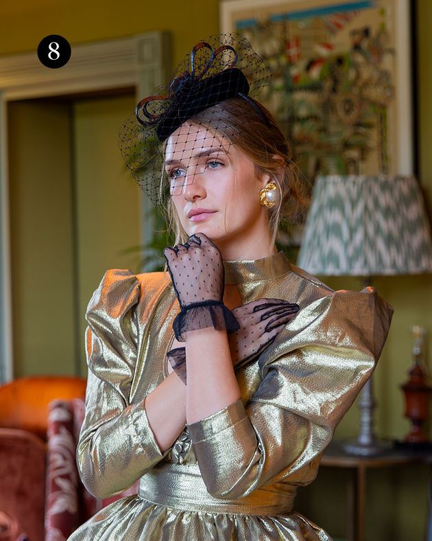 Woman wearing tulle gloves with frilled cuff in gold dress at an event. 
